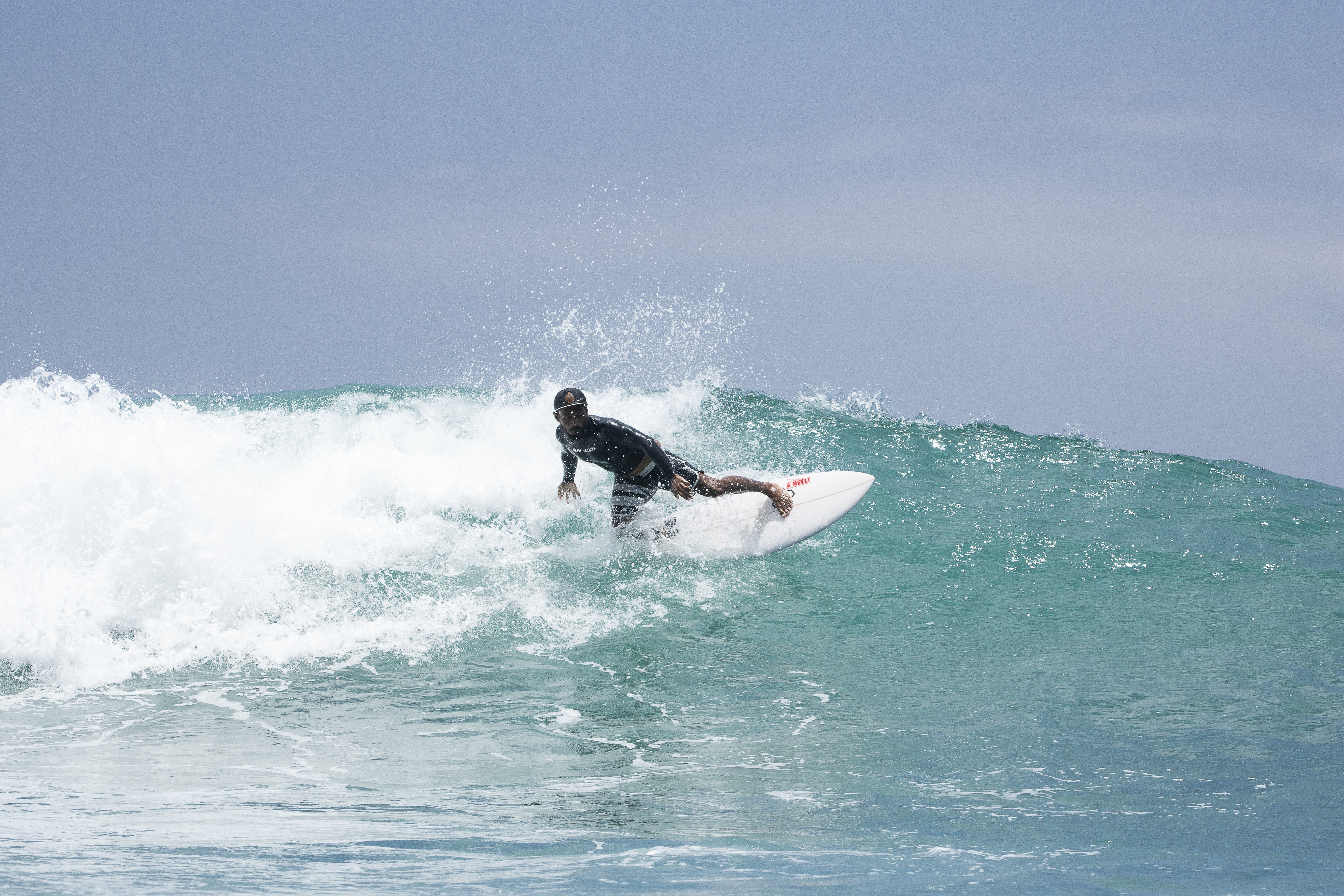Surfer carving across a clean green wave face