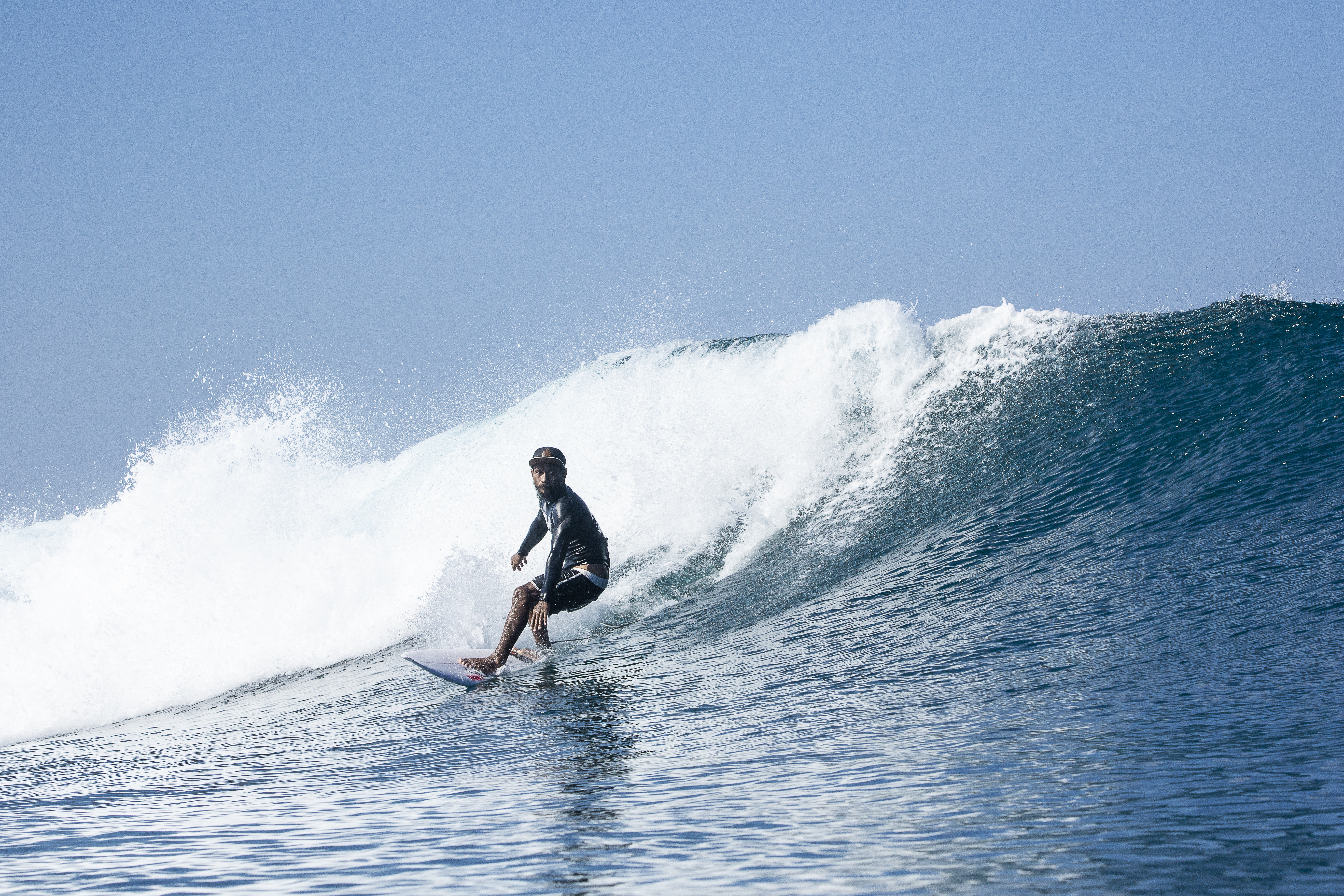 Surfer trimming down the face of a wave