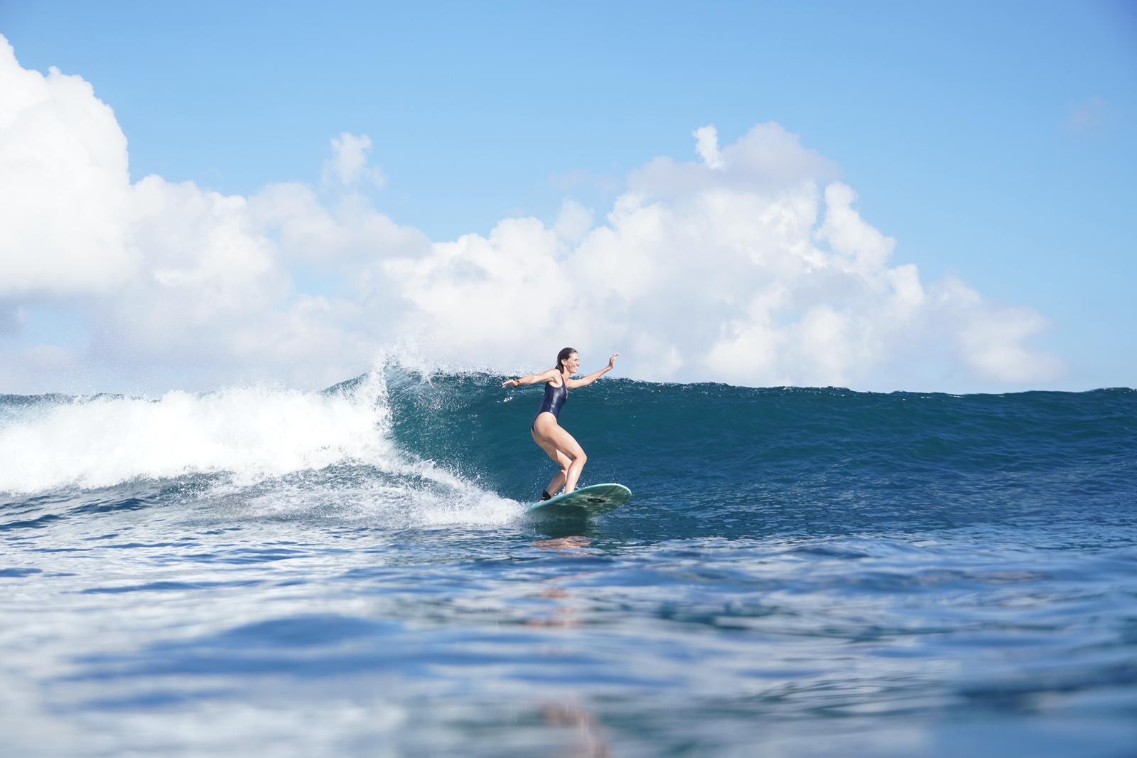 Wide view of a surfer trimming along a peeling wave